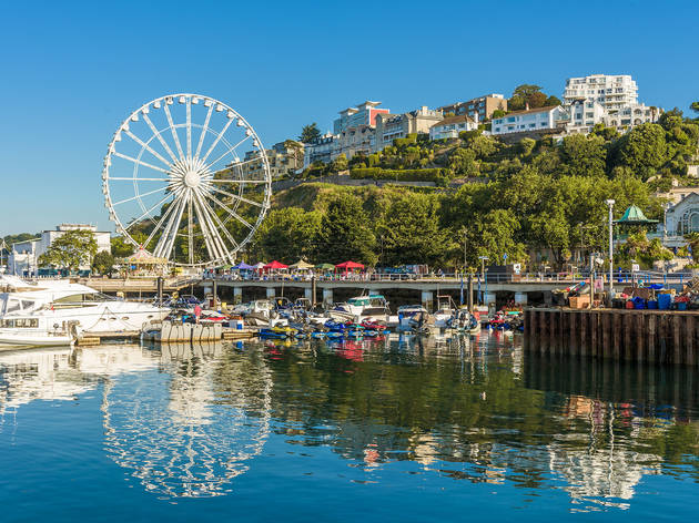 Photo of Torquay seafront and harbour with blue sky.